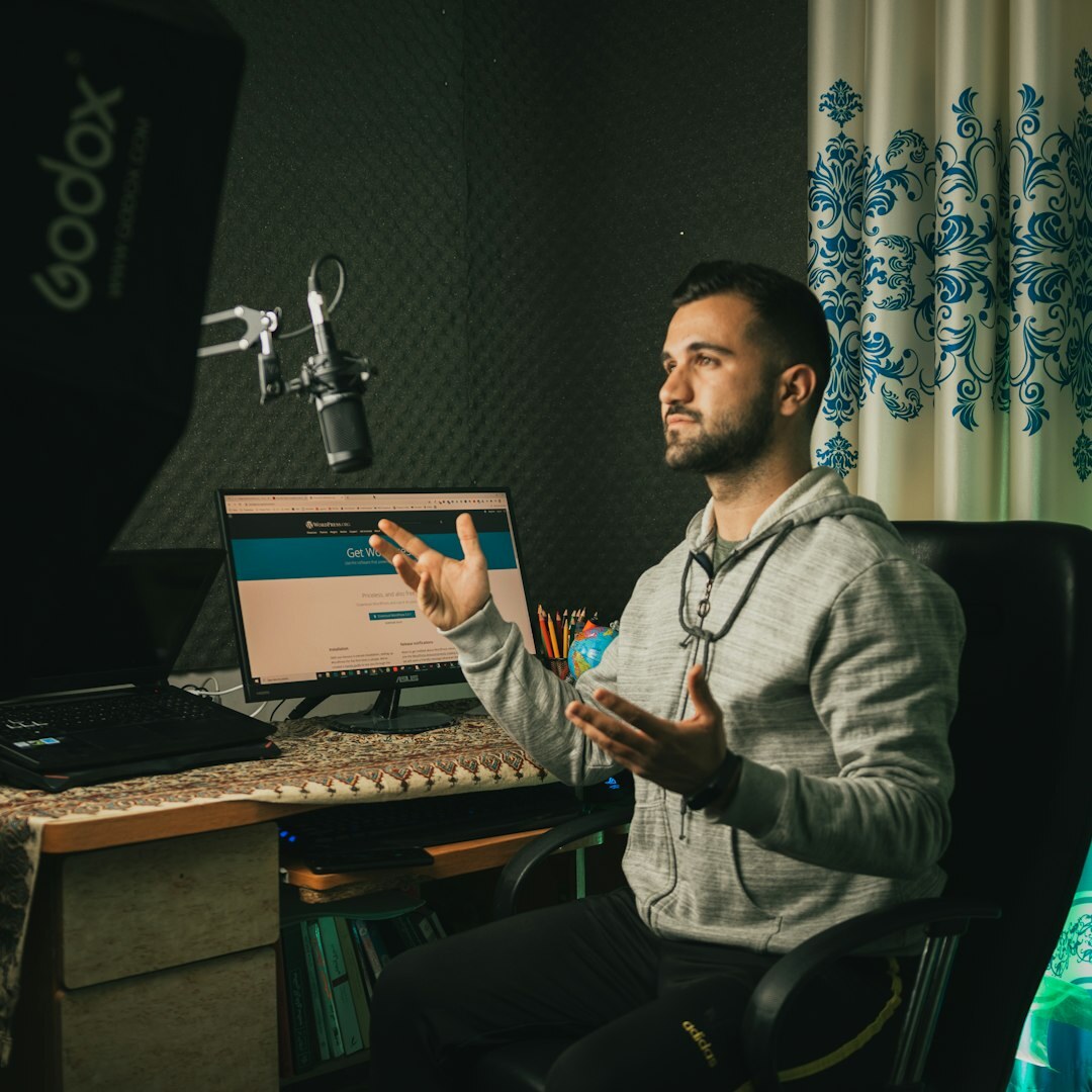 Podcast host wearing headphones speaking into a microphone in a studio